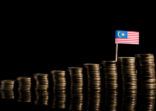Malaysian flag with lot of coins isolated on black background