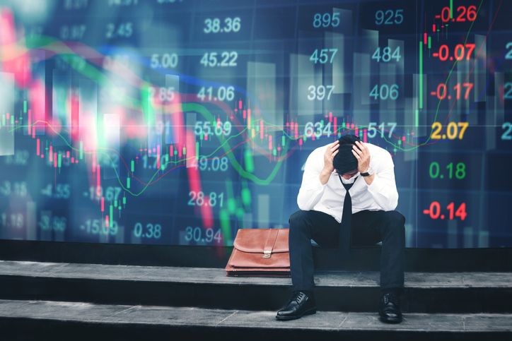 Tired or stressed businessman sitting on the walkway in panic digital stock market financial background