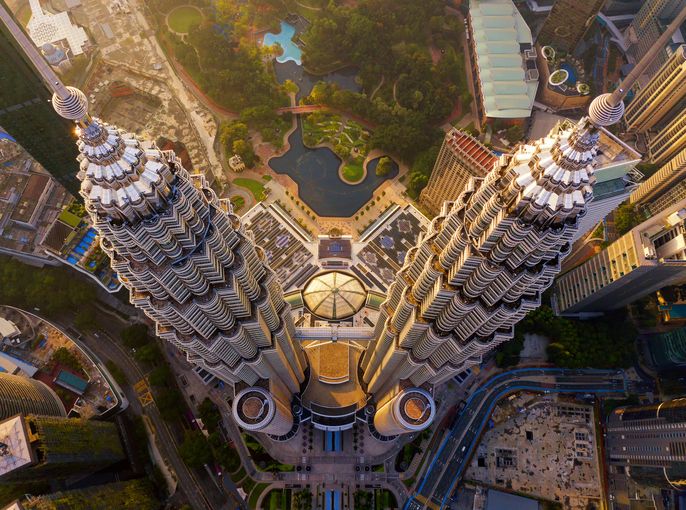 Top of Petronas Twin Towers. Aerial view of Kuala Lumpur Downtown, Malaysia. Financial district and business centers in smart urban city in Asia. Skyscraper and high-rise buildings at sunset.