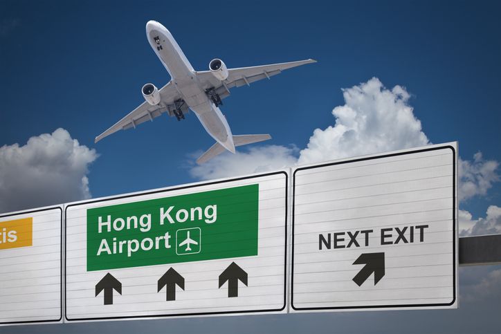 Road sign indicating the direction of Hong Kong airport and a plane that just got up.