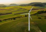 Alternative Energy Wind Turbine in Beautiful Green Landscape at Sunset