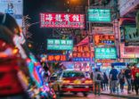 Colorful neon night street road in Hongkong with taxi