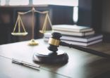 Scales of justice and Gavel on wooden table and Lawyer or Judge working with agreement in Courtroom, Justice and Law concept