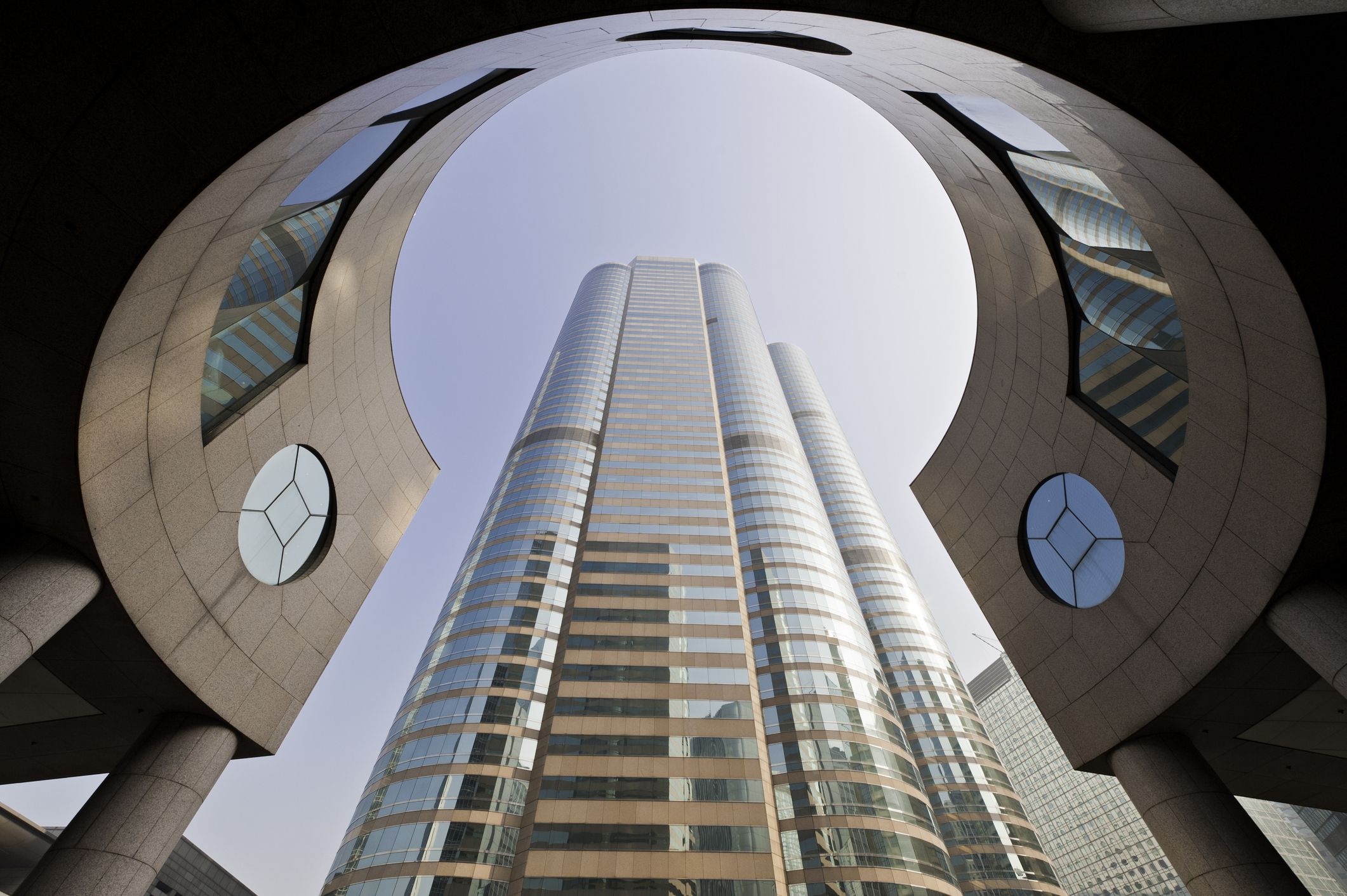 The modern business architecture of Exchange Square framing the gleaming tower of One Exchange Square, home to the Hong Kong Stock Exchange, China. ProPhoto RGB profile for maximum color fidelity and gamut.