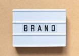 White lightbox with word brand on wood background