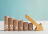 Wooden blocks with percentage sign and down arrow, financial recession crisis, interest rate decline, risk management concept