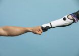 A Human and Robotic Arm Making a Fist Bump
