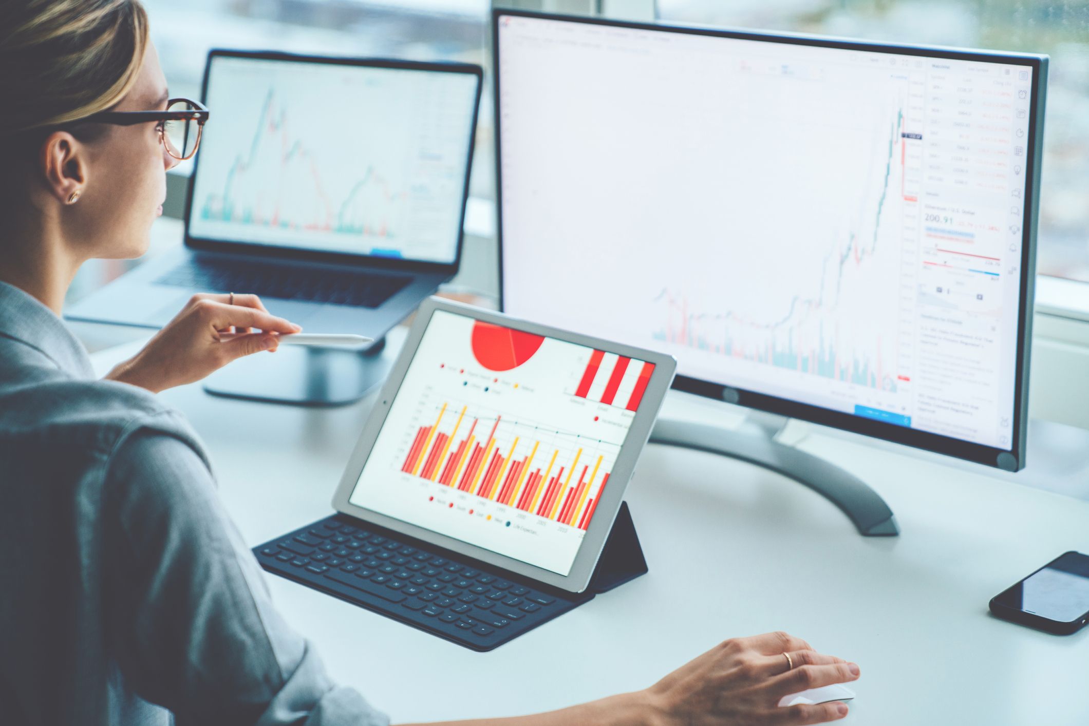 Rear view of woman financial specialist studying theory and practice blockchain technology. Female broker sitting front computer with graphs statistics of stock exchange. Earnings on raising quotes