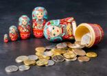 Traditional Russian toy matryoshka and money. Black concrete background.