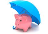 Piggy bank under a blue umbrella. Savings insurance