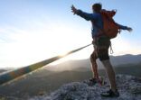 Climber celebrates arriving at the summit at sunset