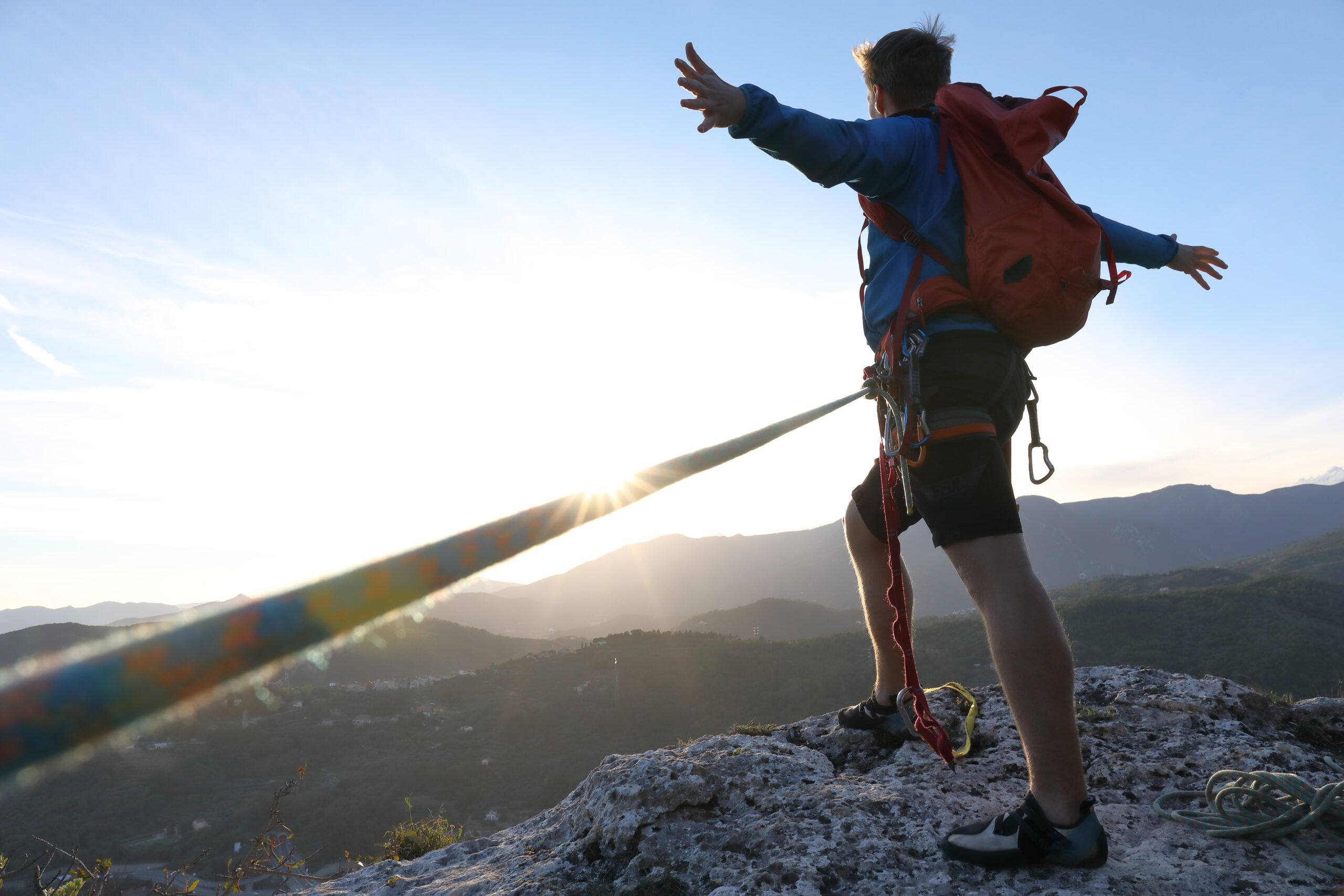 Climber celebrates arriving at the summit at sunset