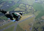 Skydiver free falling above countryside