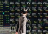 Viewing the stock board displayed on the electronic bulletin board in the business district